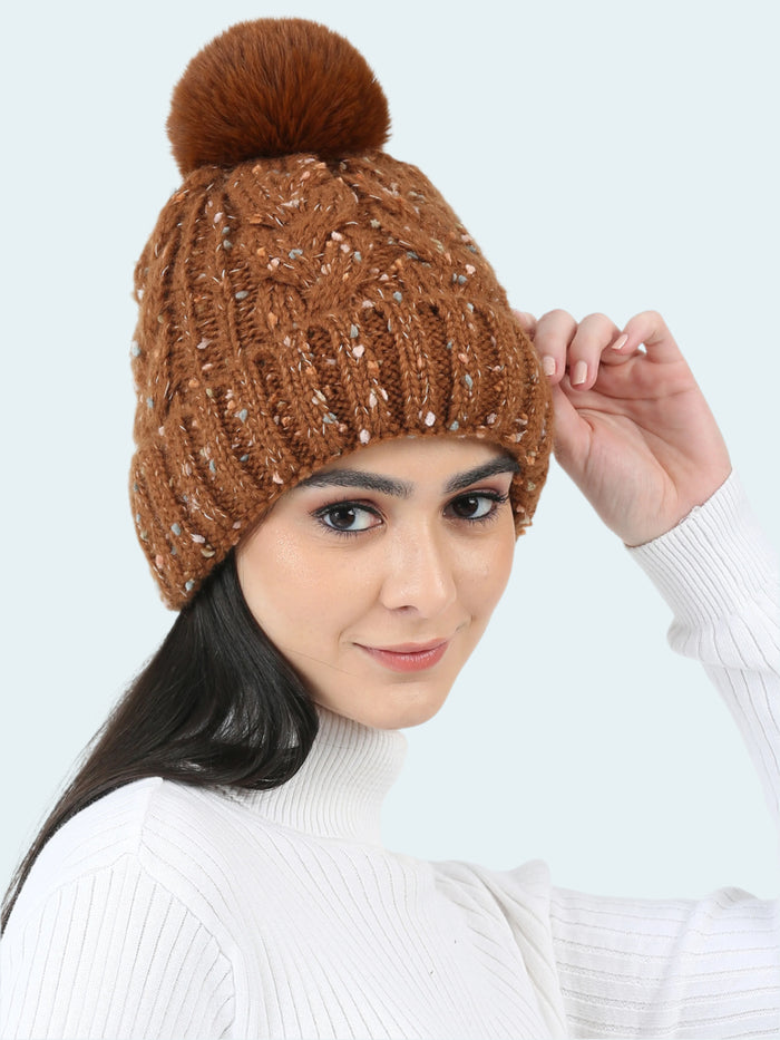 Woman wearing a brown knitted beanie with a pom-pom on a white background