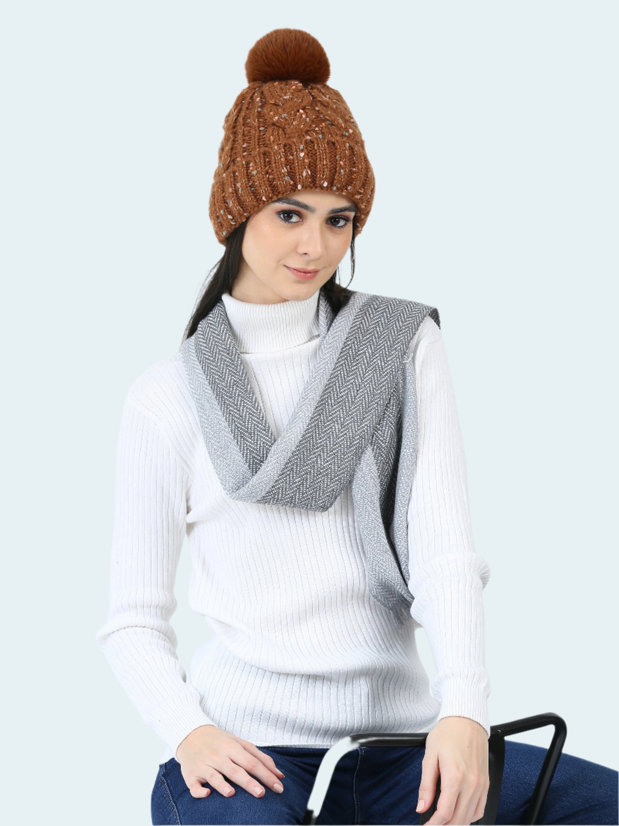 Woman wearing a brown knitted beanie and gray vest on a white background