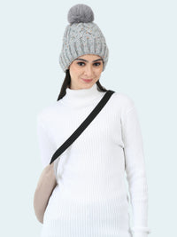 Woman wearing a gray knitted beanie with a pom-pom on a white background