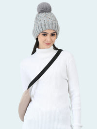 Woman wearing a gray knitted beanie with a pom-pom on a white background