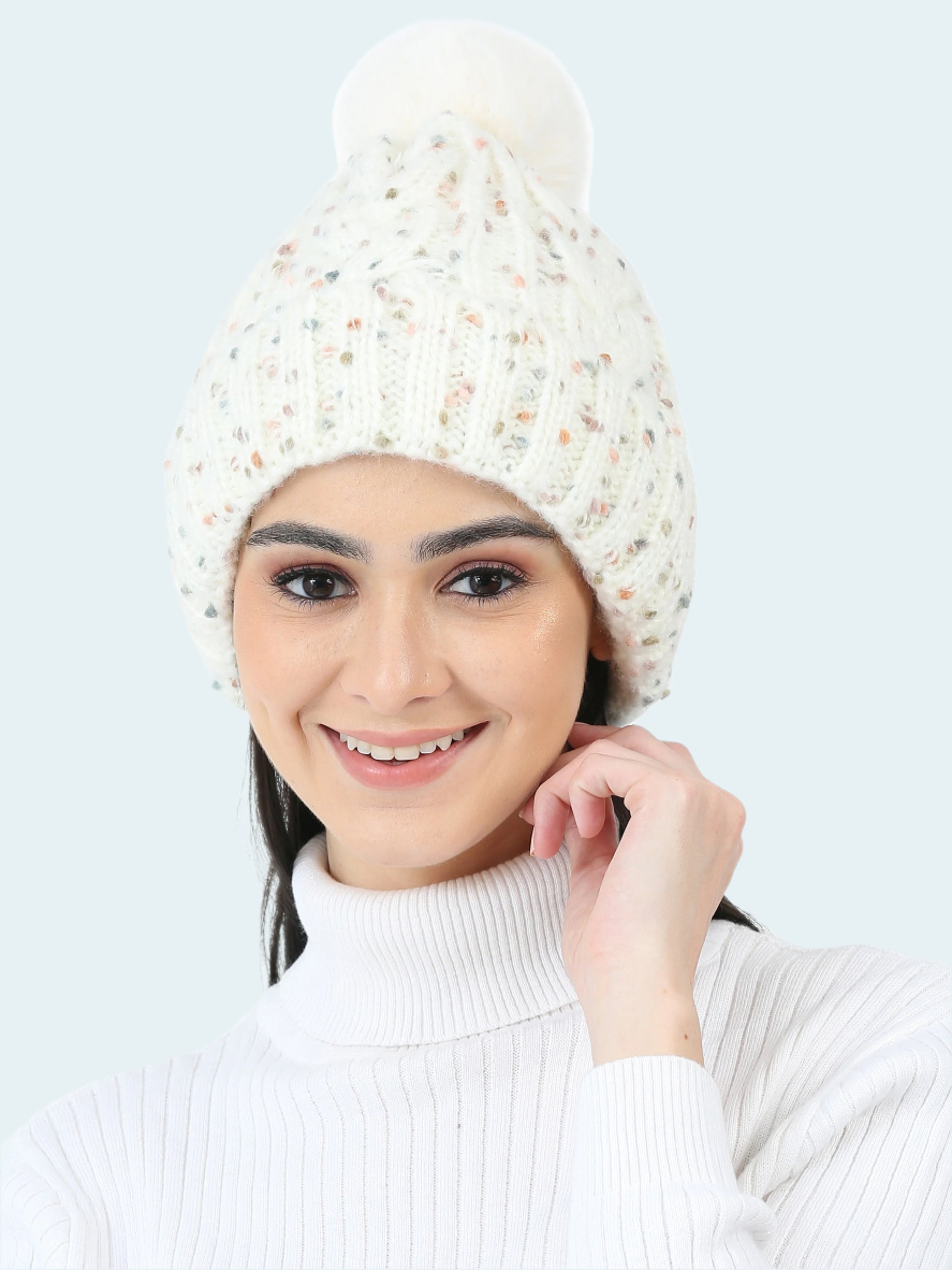 Woman wearing a white knit beanie with a pom-pom on a white background