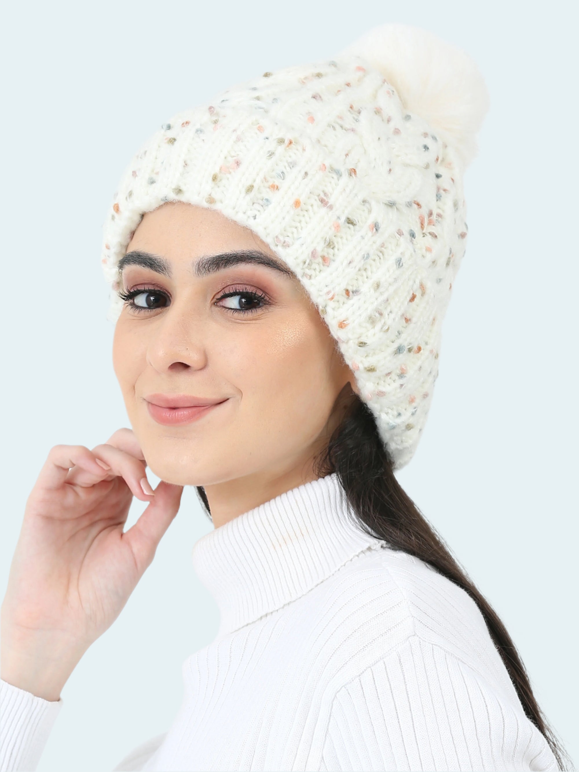 Woman wearing a textured white beanie against a plain background