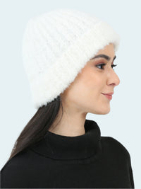 Woman wearing a white knitted beanie and black turtleneck sweater on a white background