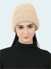 Woman wearing a beige knitted beanie on a white background