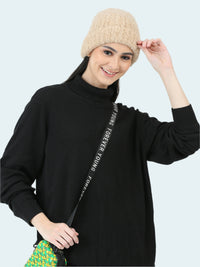 Woman wearing a black turtleneck sweater with text, beige beanie, and holding a colorful bag on a white background