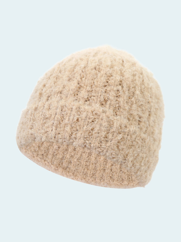 Beige knitted beanie on a white background