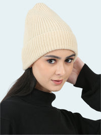 Woman wearing a beige knit beanie against a white background