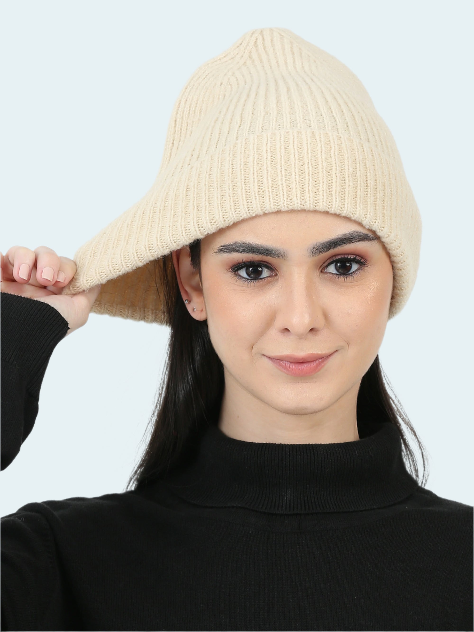 Woman wearing a beige knit hat against a white background