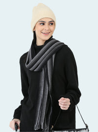 Woman wearing a black outfit with a gray scarf and cream beanie on a white background