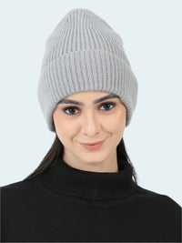 Woman wearing a gray knit beanie on a white background