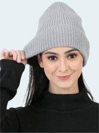 Woman wearing a gray knit beanie against a white background
