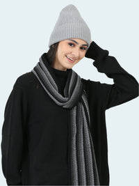 Person wearing a gray knit beanie and scarf on a white background