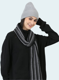 Person wearing a gray knit beanie and scarf on a white background