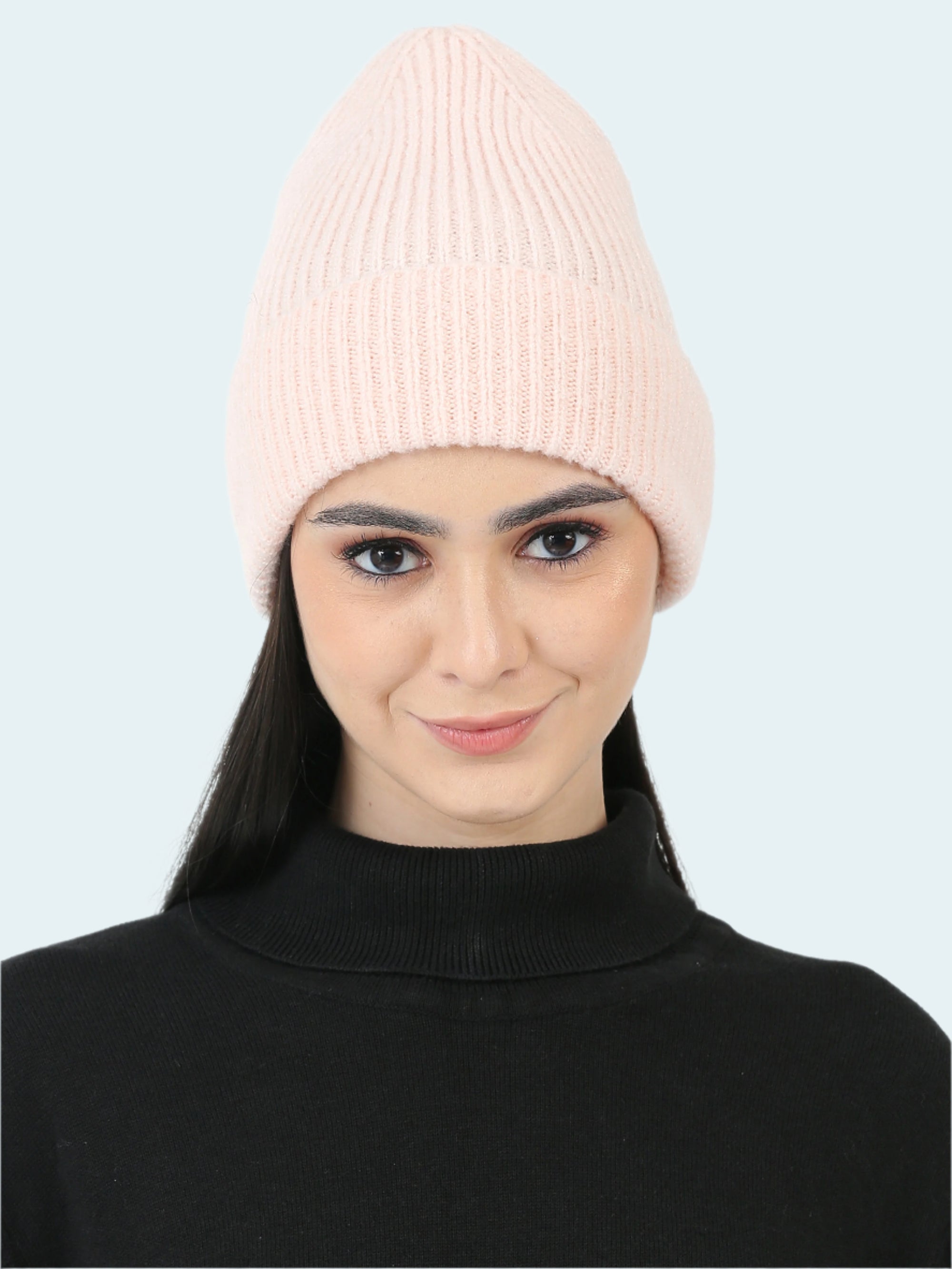 Woman wearing a pink beanie on a white background