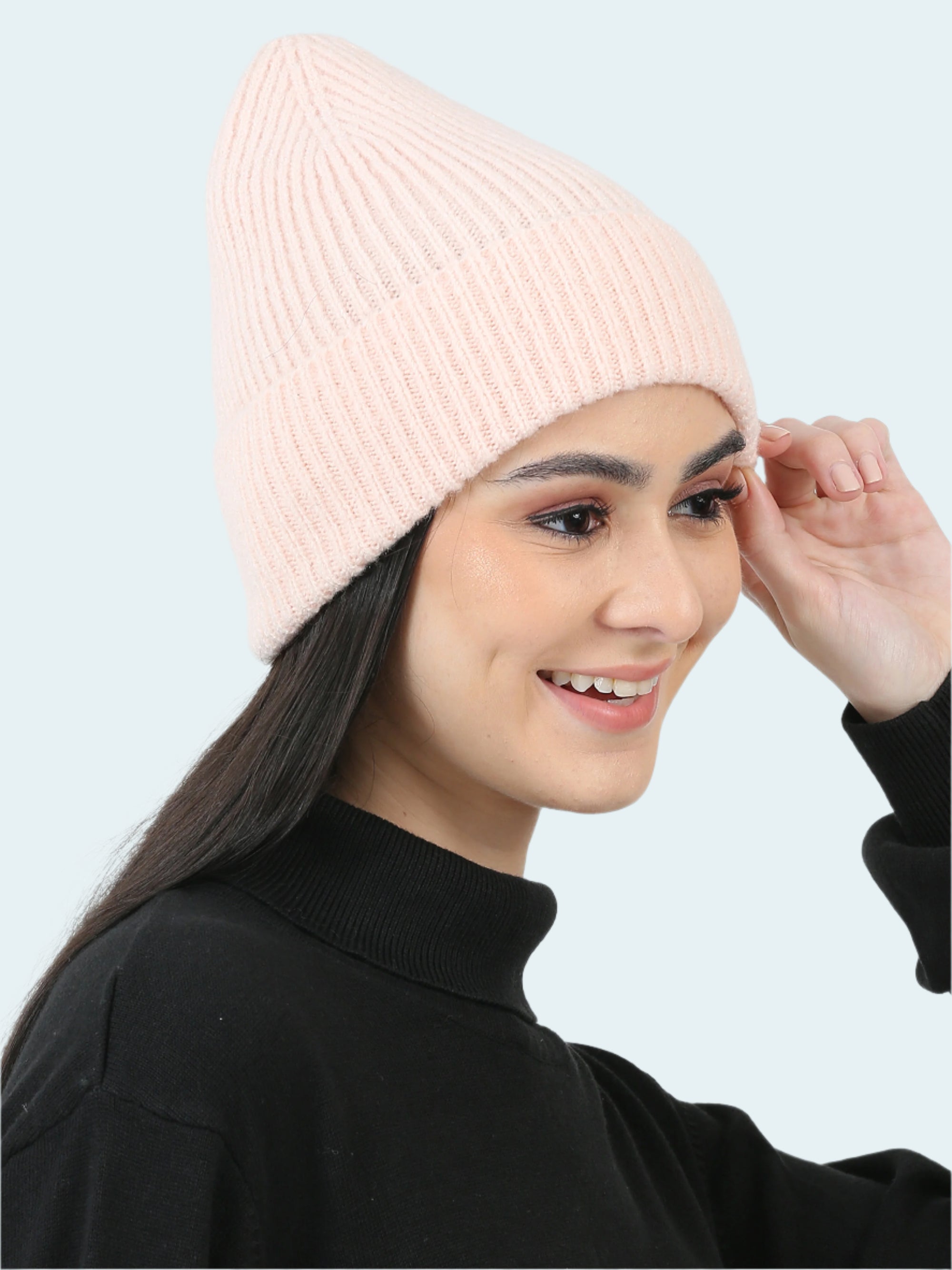 Woman wearing a pink beanie against a light gray background