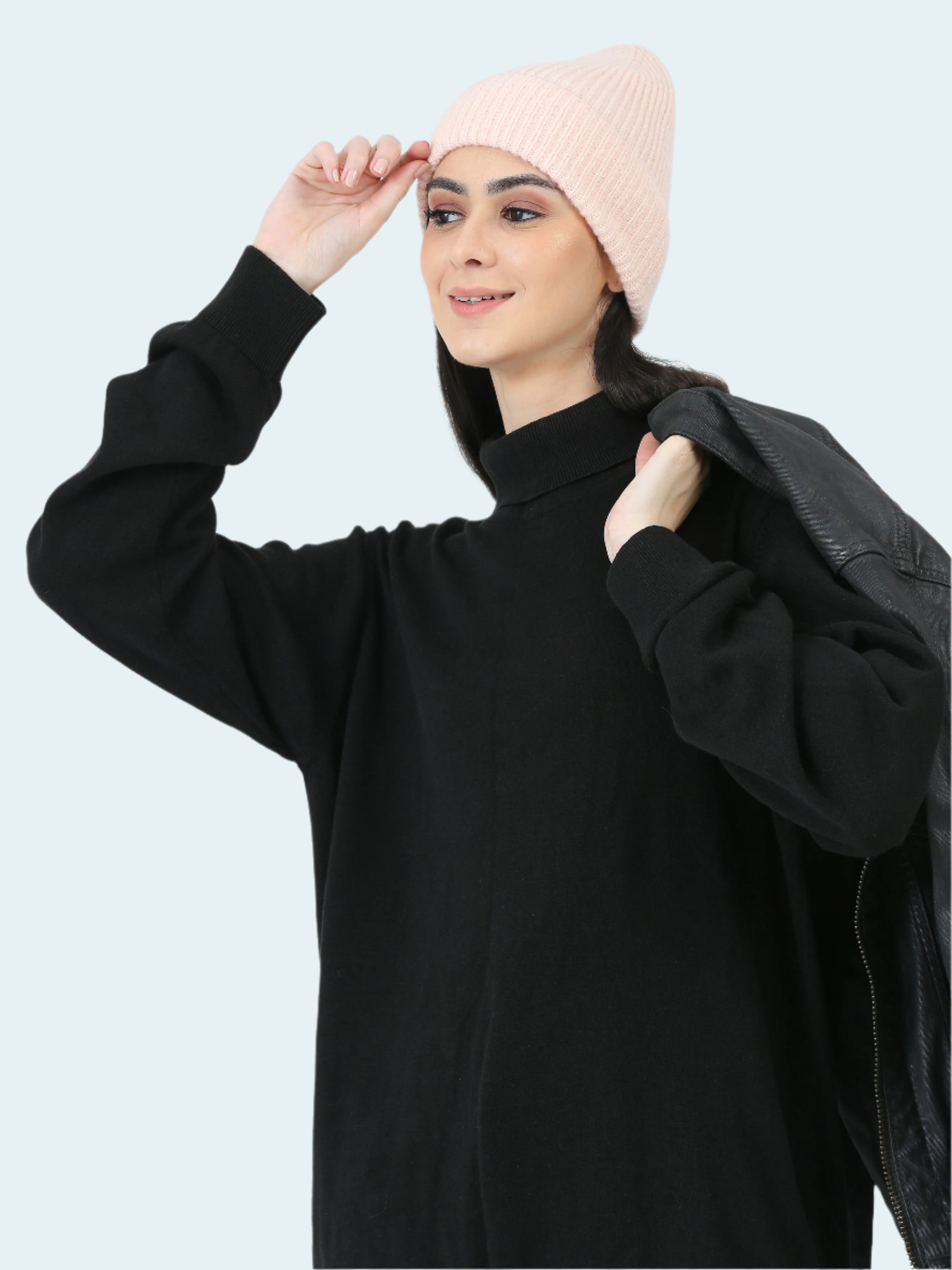 Woman wearing a black outfit with a pink beanie on a white background