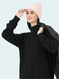 Woman wearing a black outfit with a pink beanie on a white background