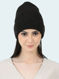 Woman wearing a black knit beanie against a white background