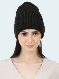 Woman wearing a black knit beanie against a white background