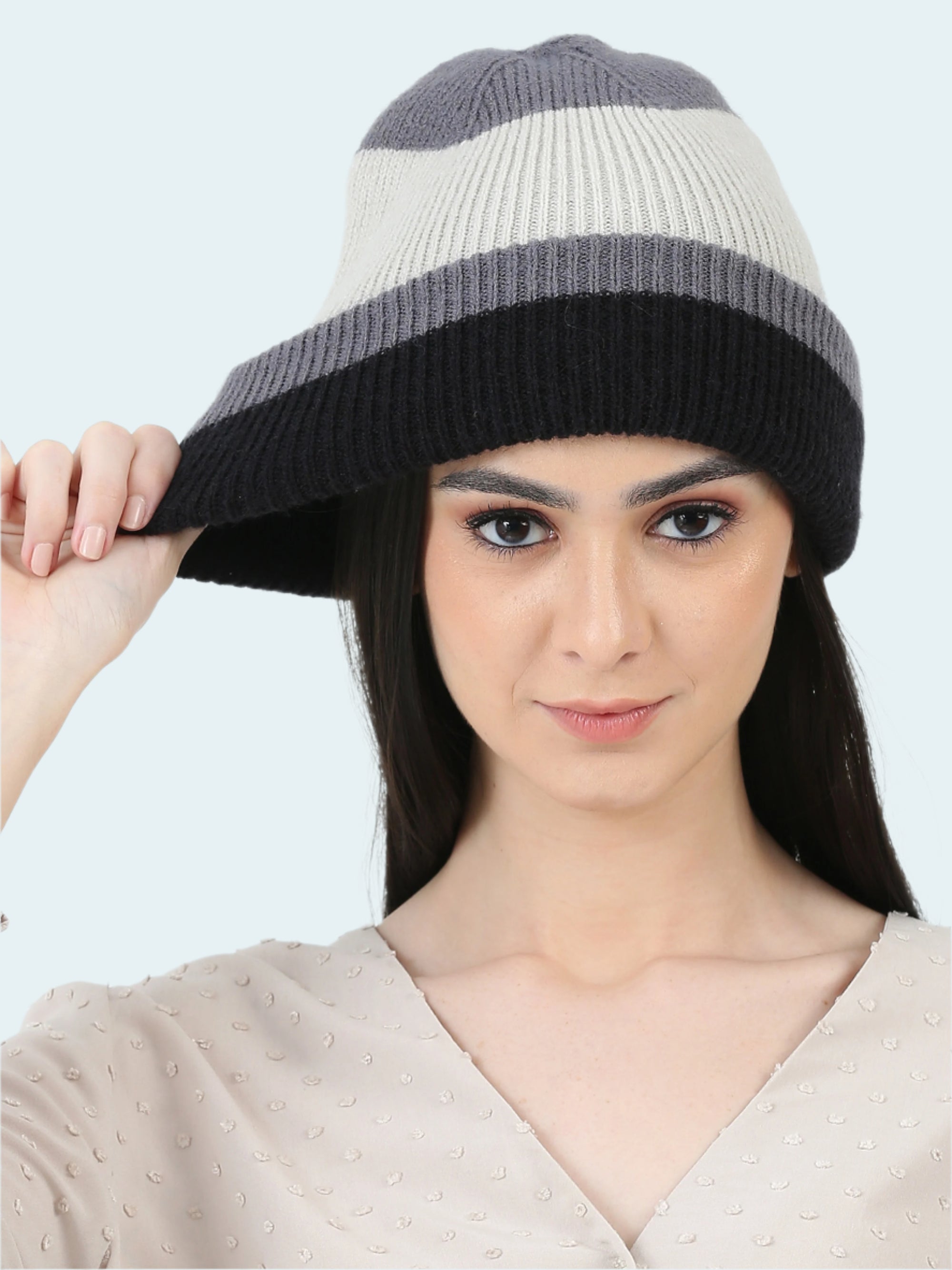 Woman wearing a two-tone knit hat on a white background