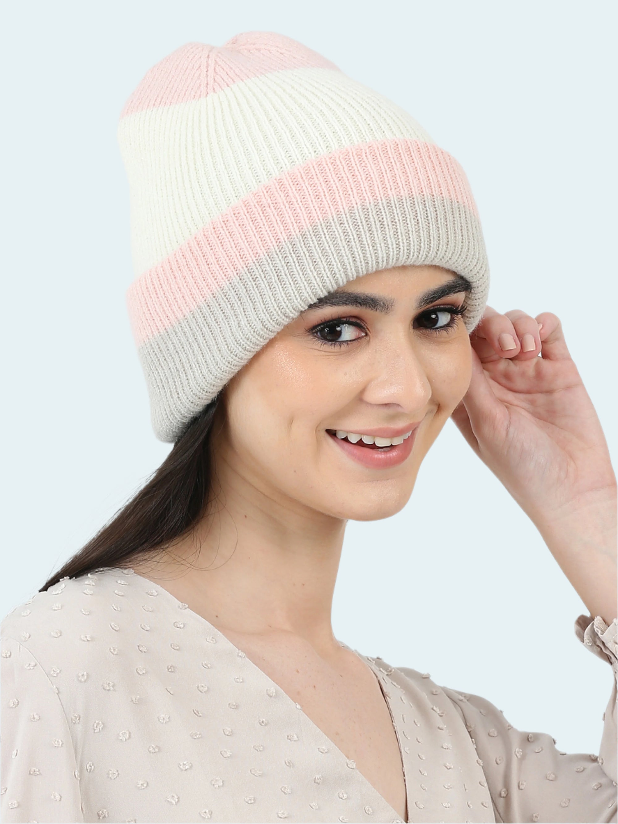 Woman wearing a two-tone pink and gray knit beanie on a white background