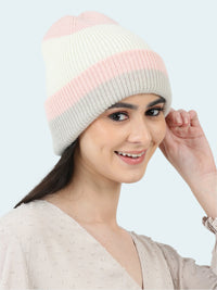 Woman wearing a two-tone pink and gray knit beanie on a white background