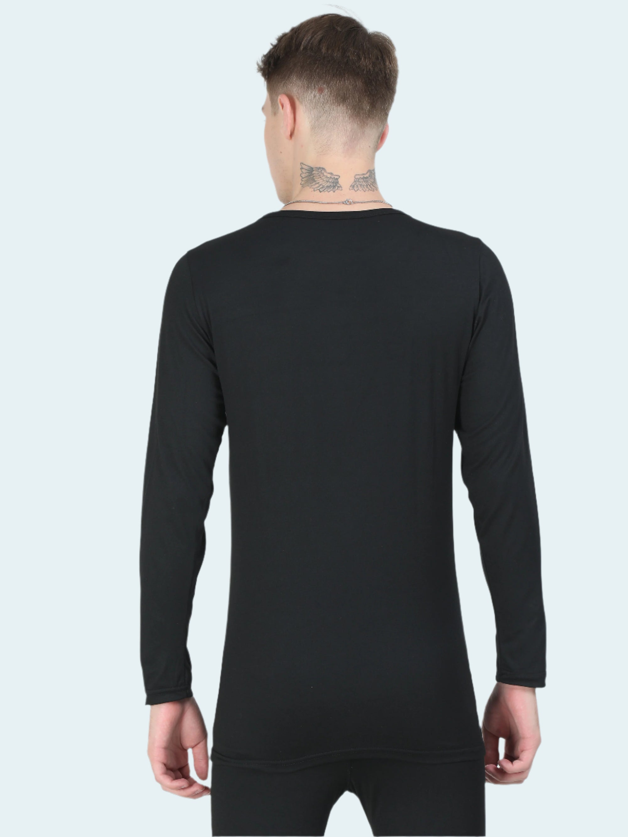 Person wearing a black long-sleeve base layer top on a white background