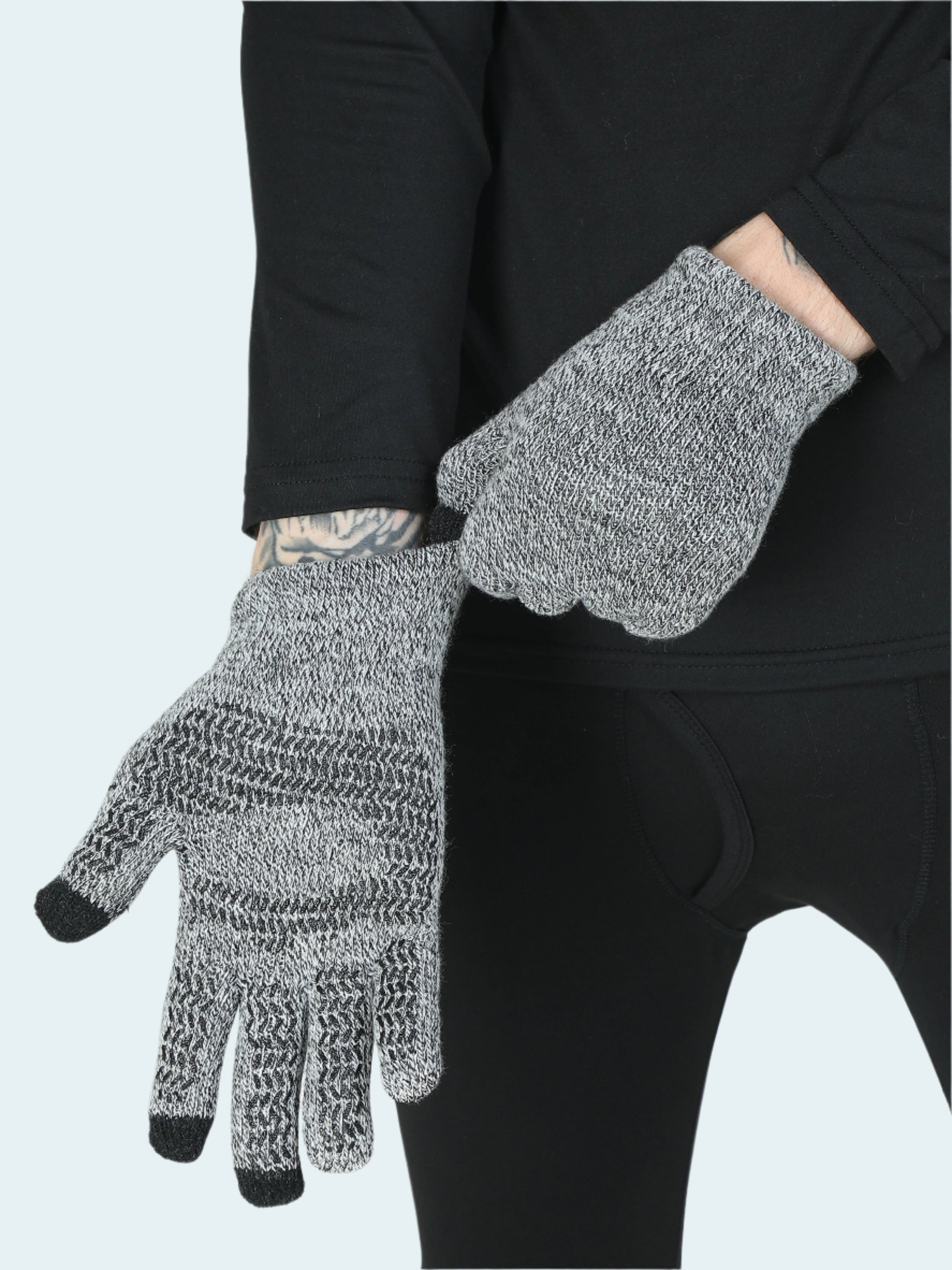 Person wearing gray gloves with black tips on a white background