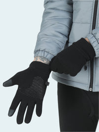 Person wearing black gloves with touch screen tips on a light gray background