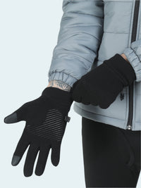 Person wearing black gloves with touch screen tips on a light gray background