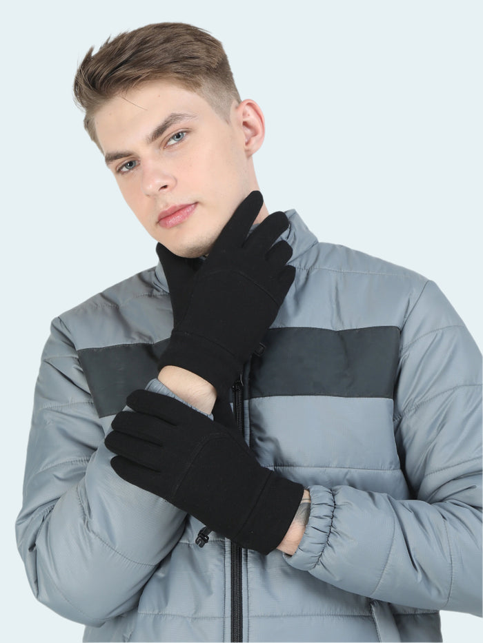 Person wearing black gloves and a gray jacket on a white background
