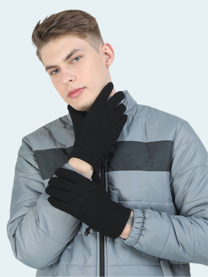 Person wearing black gloves and a gray jacket on a white background