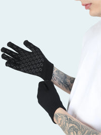 Black gloves with textured palm held by a person with tattoos on a white background