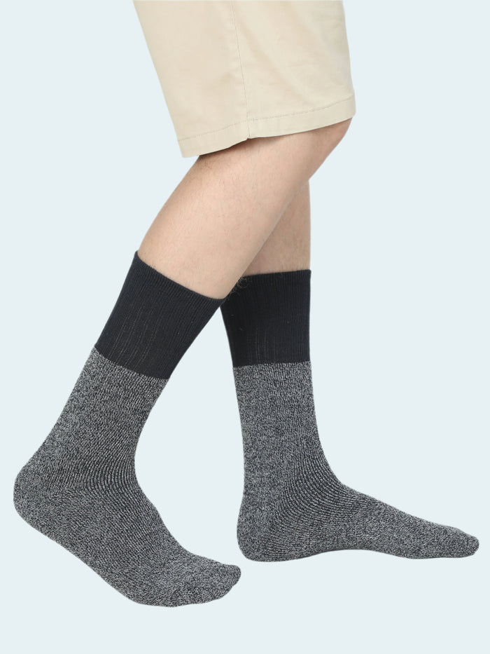 Person wearing black and gray socks on a white background