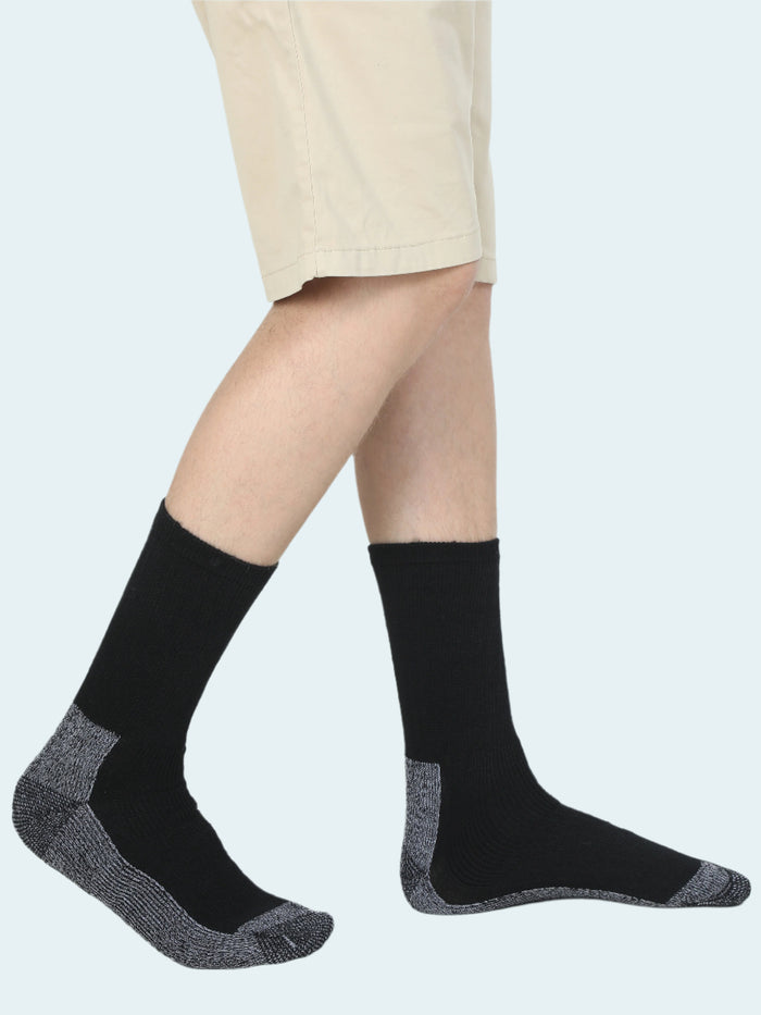 A pair of black HEAT LOGIC thermal socks worn with beige shorts, showcasing the socks' design and fit.
