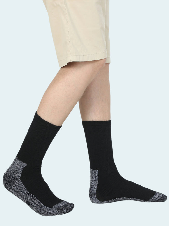 A pair of black HEAT LOGIC thermal socks worn with beige shorts, showcasing the socks' design and fit.
