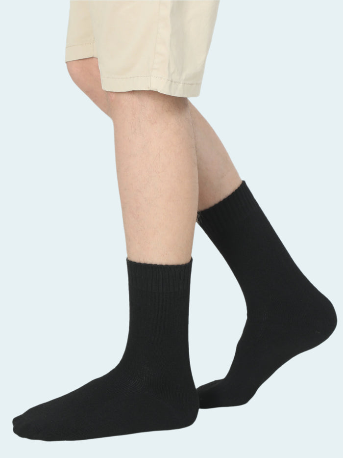 A pair of black thermal socks worn on legs against a white background