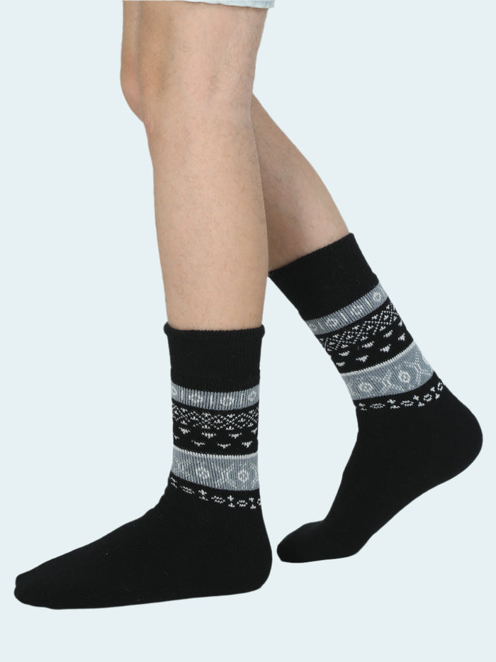 Black socks with gray pattern worn by a person on a white background