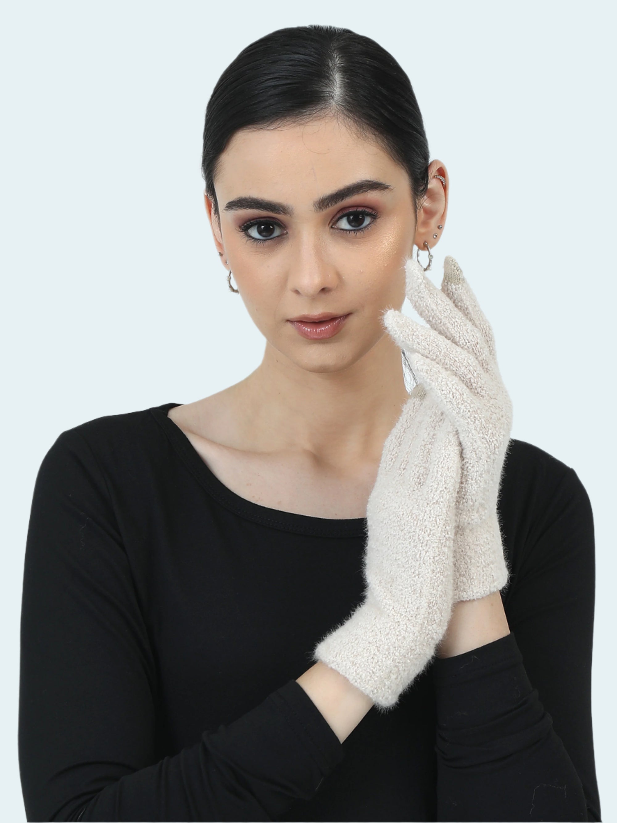 Woman wearing a black top and white gloves against a light gray background