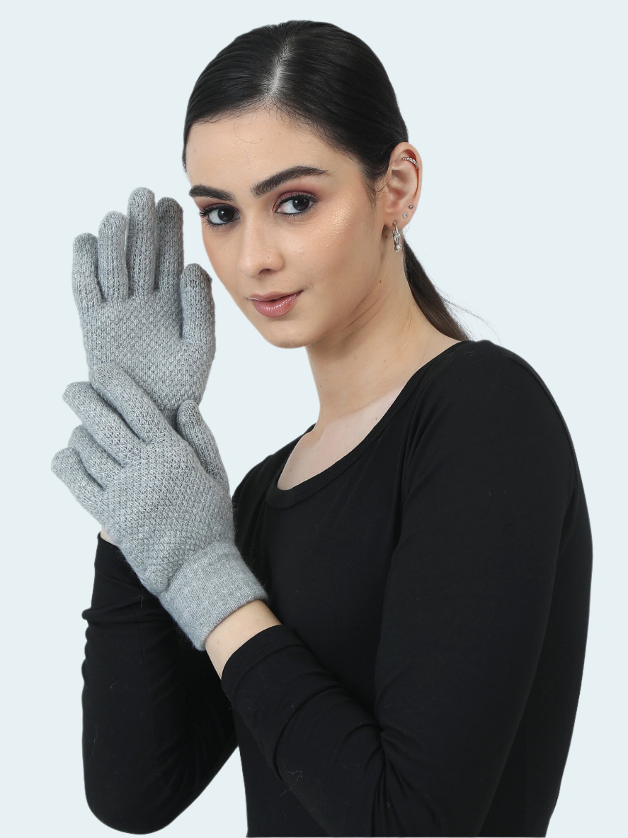 Woman wearing gray gloves against a white background