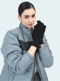 Woman wearing a gray jacket and black gloves on a white background