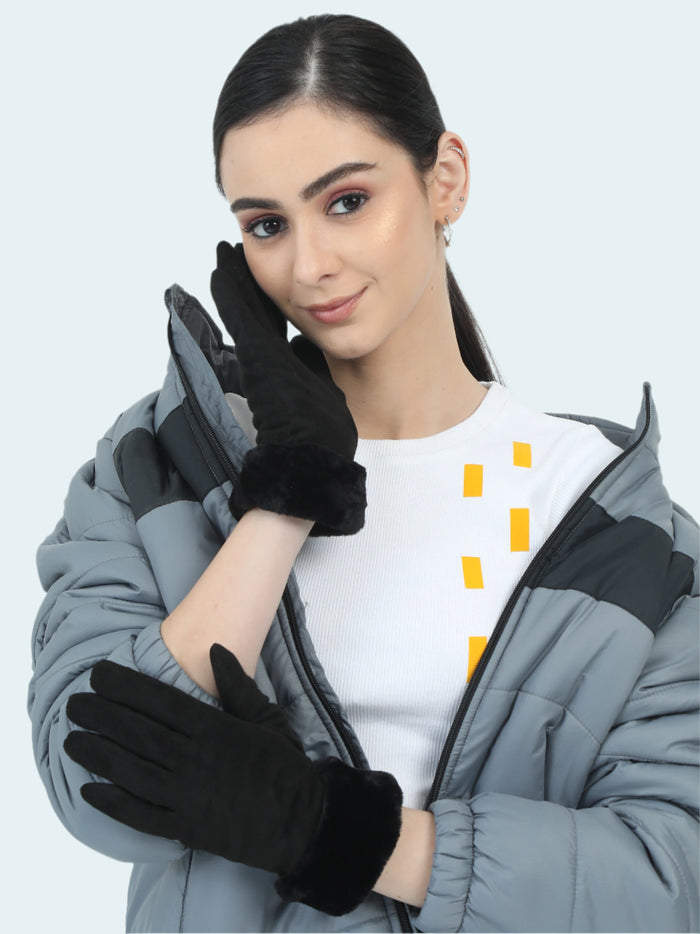 Woman wearing black gloves and a gray coat on a light gray background