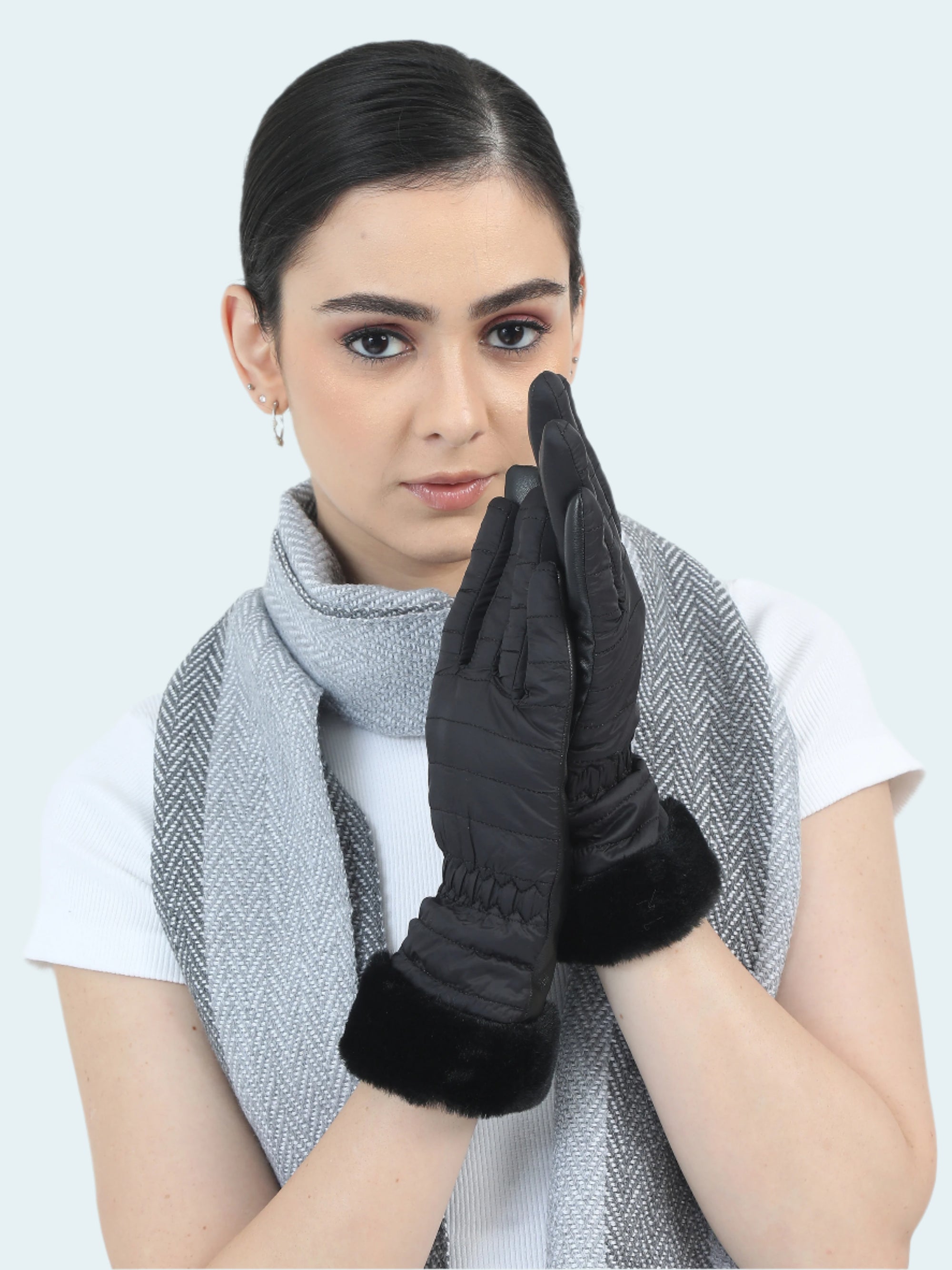 Woman wearing black gloves and a gray scarf on a white background