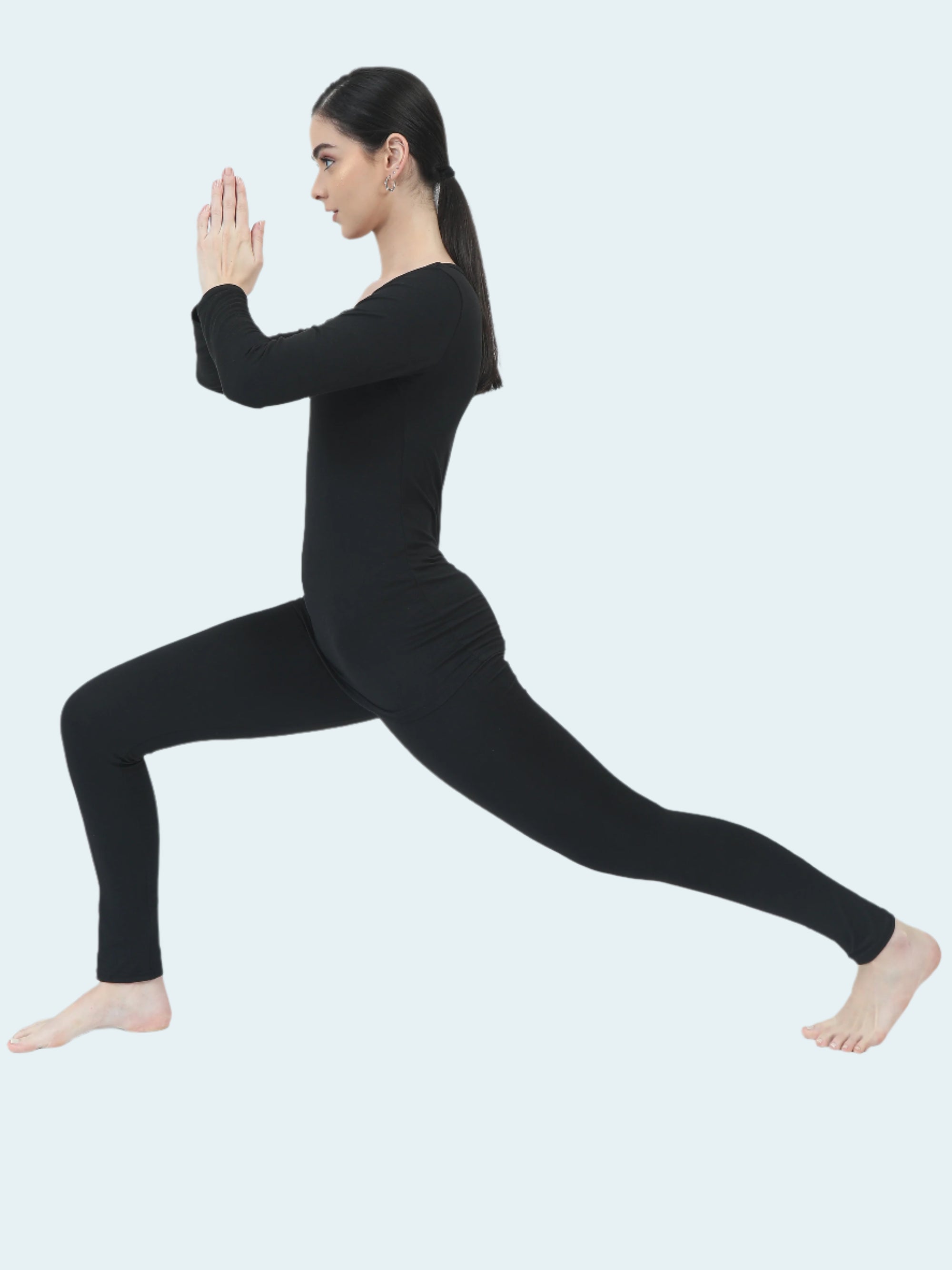 Person wearing a black base layer in a yoga pose on a white background