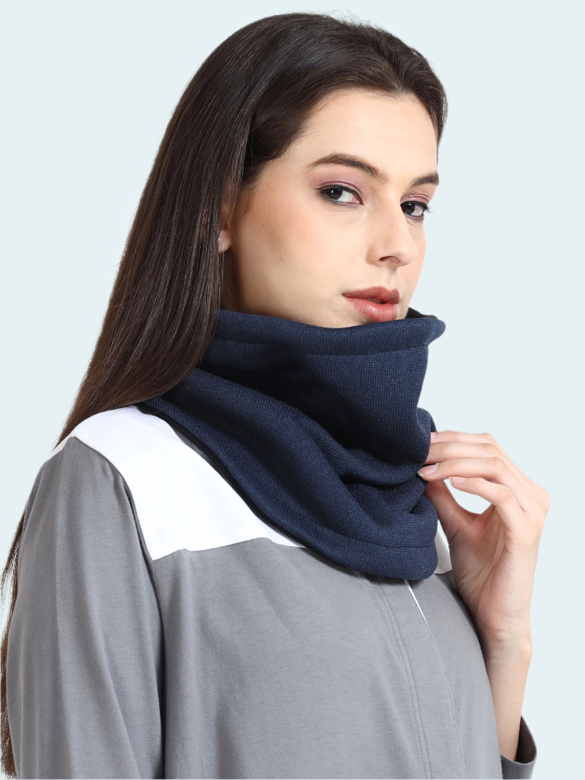 Woman wearing a navy blue scarf on a plain background