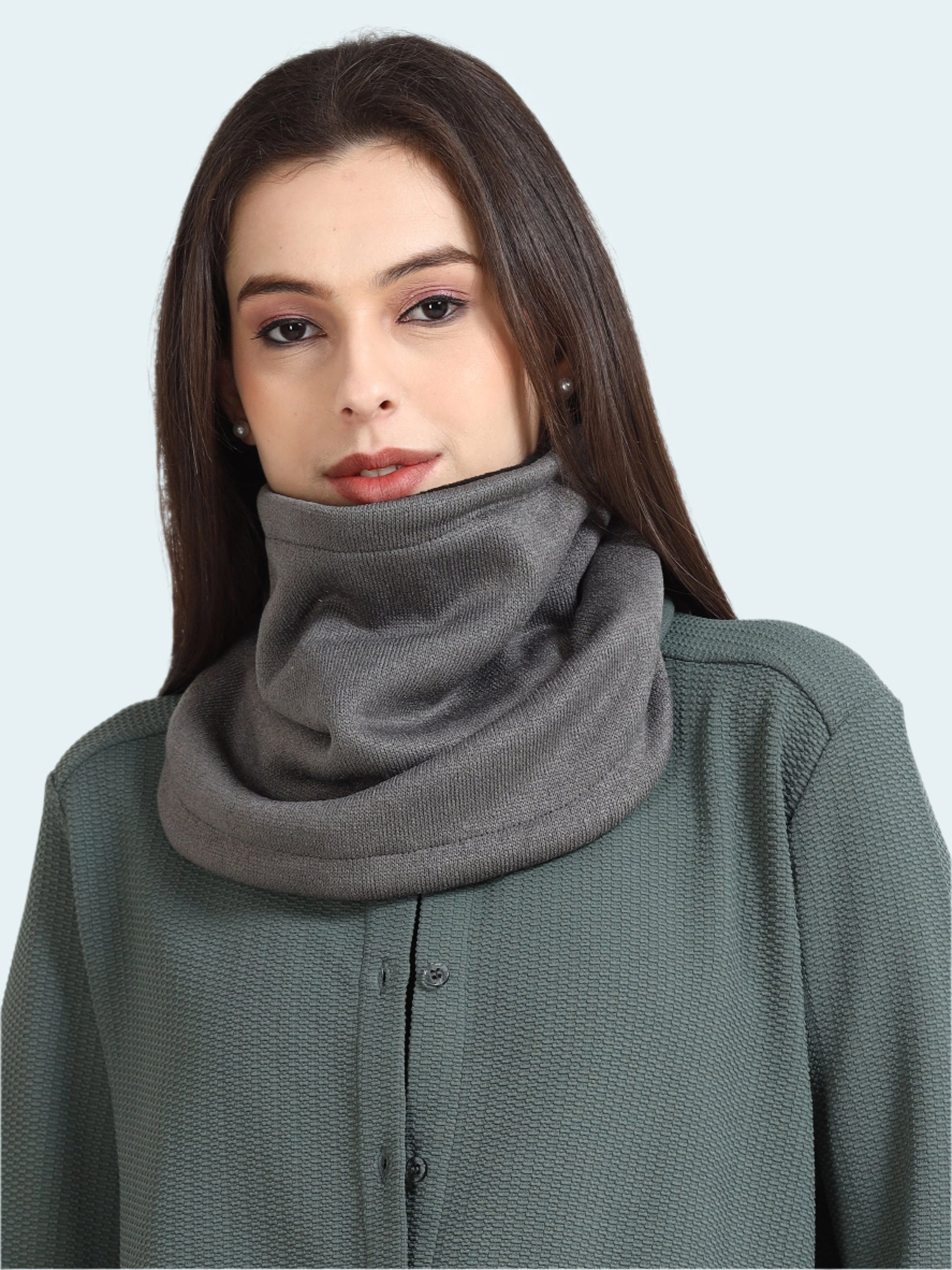 Woman wearing a gray scarf on a plain background