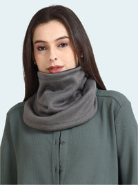 Woman wearing a gray scarf on a plain background