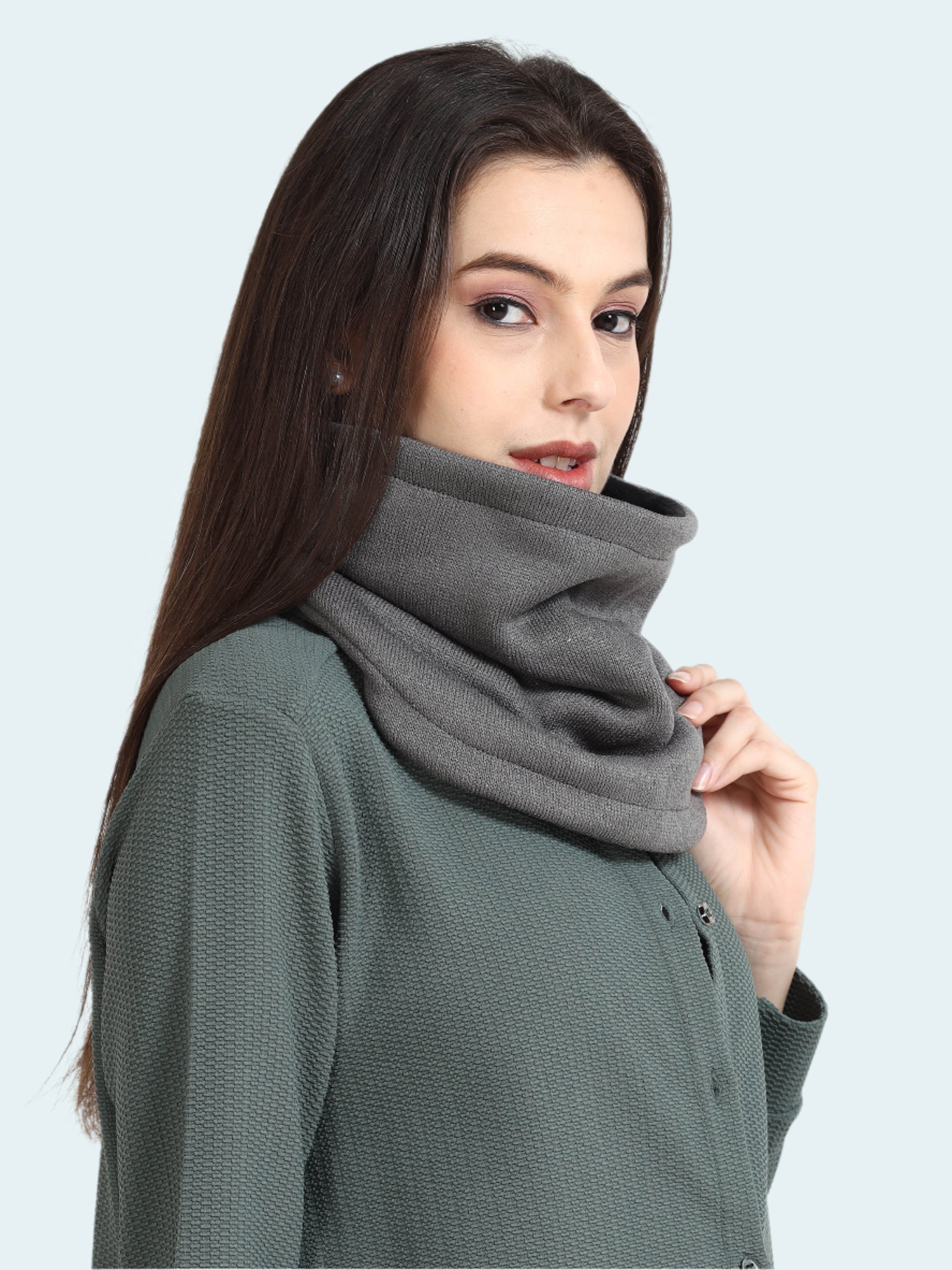 Woman wearing a gray cowl neck sweater against a white background