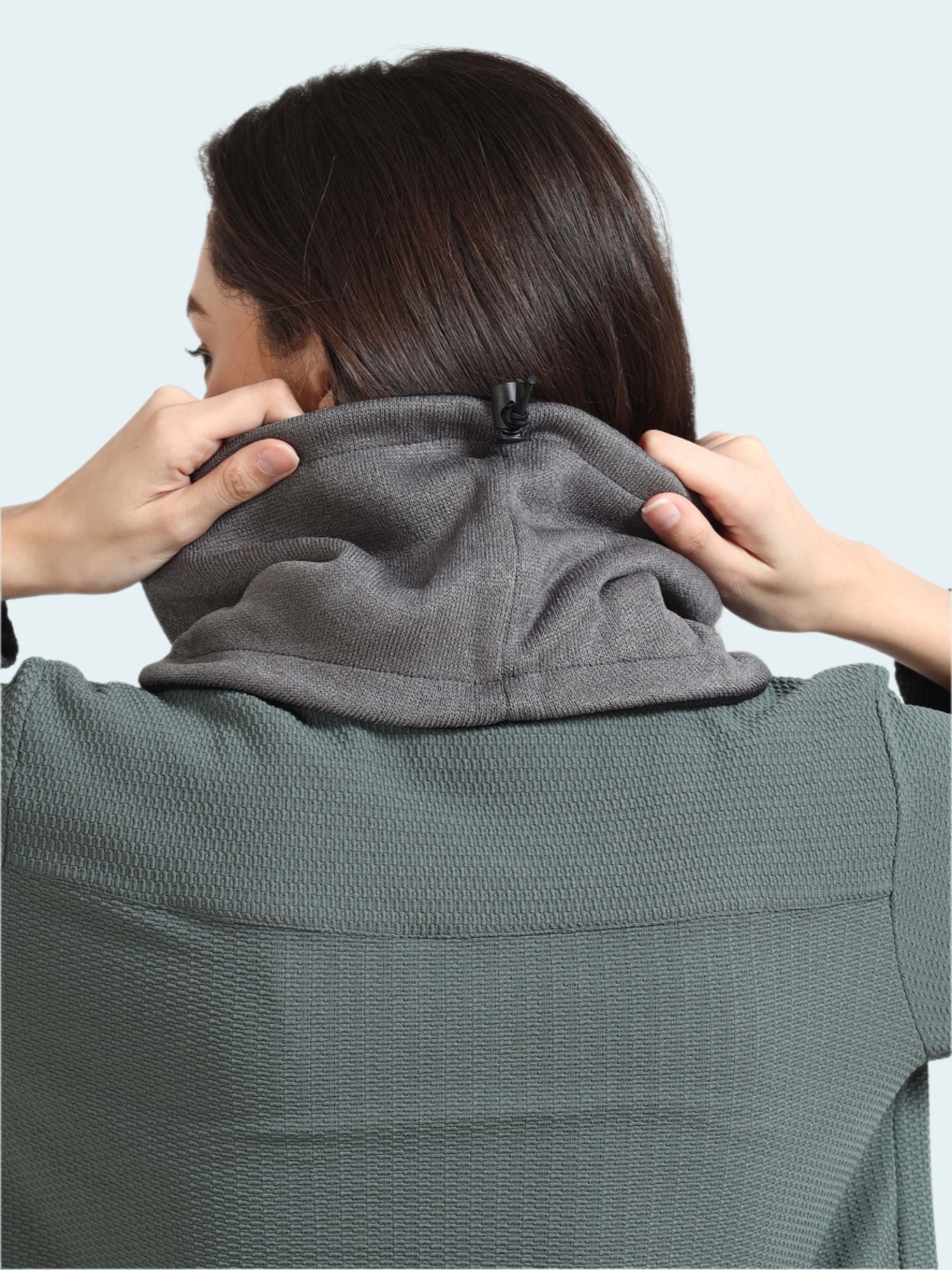 Person wearing a gray neck gaiter on a white background