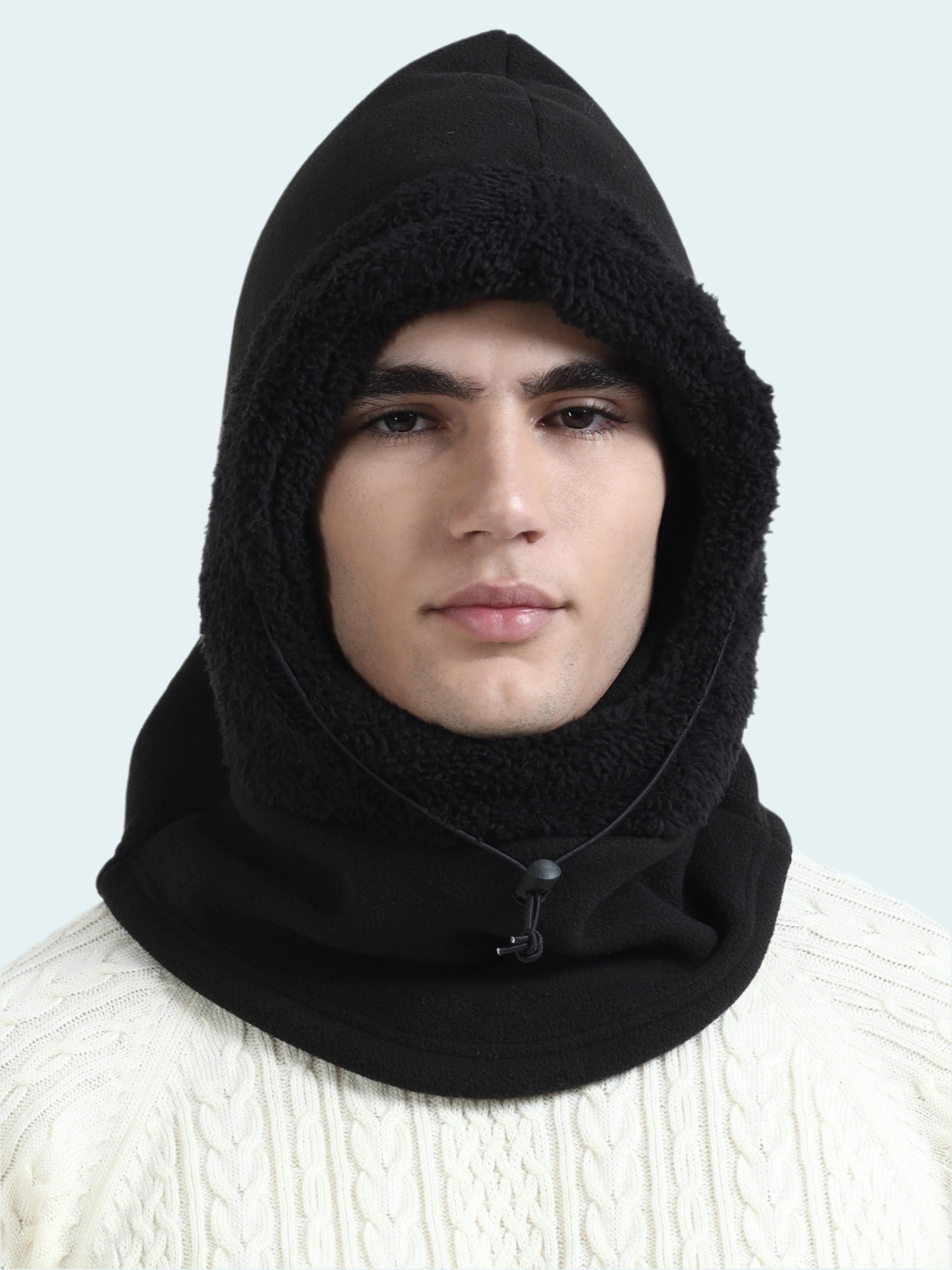Person wearing a black balaclava against a white background